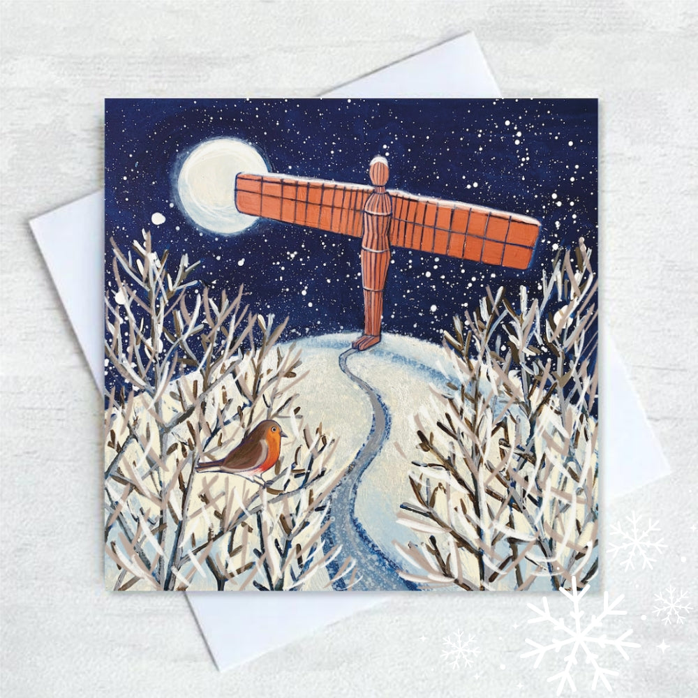 Festive Christmas card by Joanne Wishart featuring a snowy path leading to the Angel of the North, with a curious robin observing. The landmark, bathed in bright moonlight, stands tall over snow covered Gateshead hill.