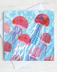 A greetings card featuring pink jelly fish swimming g through bubbly sea.